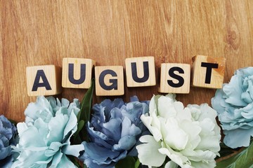 august alphabet letter wooden cube with space copy on wooden background and flower decoration