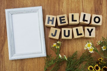 hello july with artificial flower on wooden background © may1985