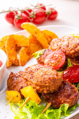 Meatballs skewers of tomato, paprika and baked potato quarters