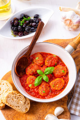 Baked mini meatballs in tomato sauce with basil