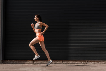 Naklejka premium young attractive female runner training in sportswear