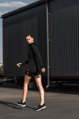 Fototapeta na wymiar attractive sportswoman walking in black thermal clothes