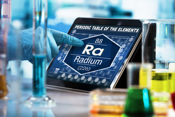 researcher working on the digital tablet data of the chemical element Radium Ra / Scientist...