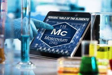 researcher working on the digital tablet data of the chemical element Moscovium Mc / Scientist...