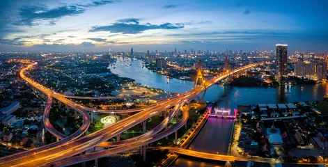  Aerial view of Bhumibol suspension bridge cross over Chao Phraya River in Bangkok city with car on the bridge at sunset sky and clouds in Bangkok Thailand. © Travel man