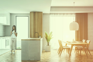 Side view white and wooden kitchen, table, woman