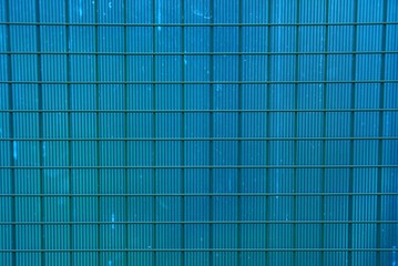 texture of a dirty blue plastic wall with an iron grill