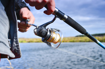 A fisherman catches a fish. Spinning reel closeup. Shallow depth of field on the spool of fishing line