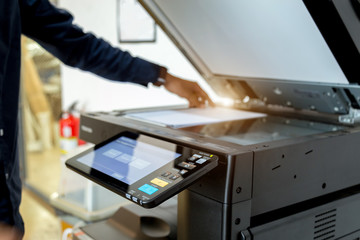 Bussiness man Hand press button on panel of printer, printer scanner laser office copy machine supplies start concept.