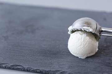 Vanilla ice cream ball on dark background.