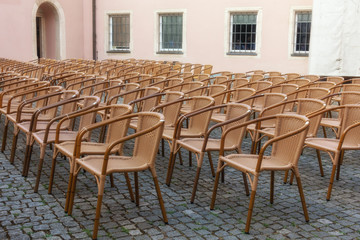 Empty chairs in front of a stage in a backyard