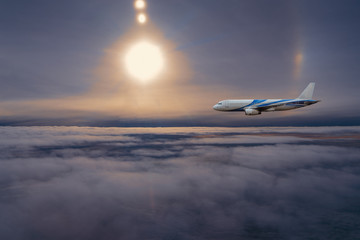 Naklejka na ściany i meble Airplane in the sky at sunrise