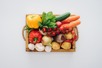 top view of box with fresh organic vegetables isolated on white