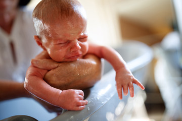 Wet baby crying while bathing