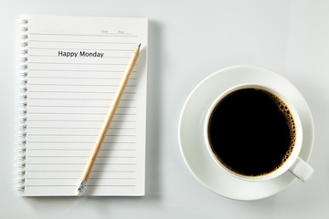 White cup of coffee morning on wooden table with notebook