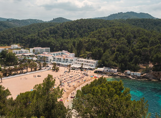 Fototapeta na wymiar Playa del Puerto de San Miguel, En Ibiza, España. Playa tranquila rodeada de acantilados y vegetacion, preferida por familias con niños