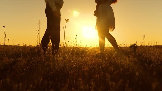 Married couple with baby hugging at sunset in sun. Evening walk of dad, mom and baby.