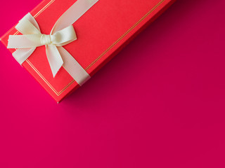 Red gift box on a bright scarlet background. Love and gifts.View from the top, diagonally