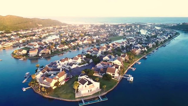 Aerial footage flying over a upmarket Marina development in Port Alfred South Africa from the river side towards the ocean