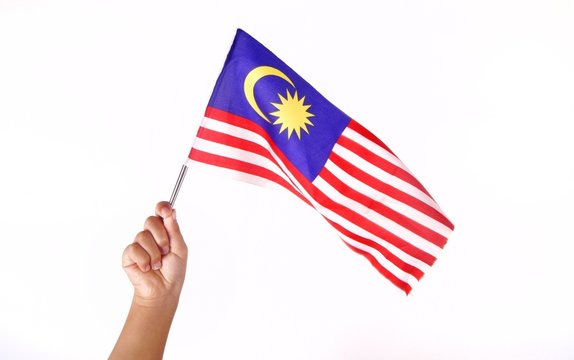 Hand holding Malaysia flag isolated on white background