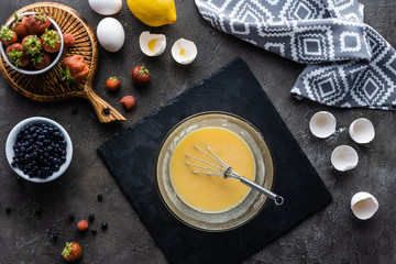 top view of making cream for pie process and arranged ingredients on dark grey surface