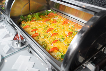 Hot snack with vegetables in bowl on the buffet table