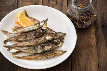 Grilled fish capelin or shishamo on white plate