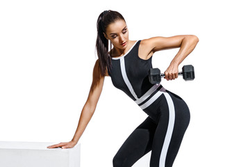 Athletic woman doing exercises with dumbbells for hands. Photo of fitness model in black sportswear isolated on white background. Strength and motivation