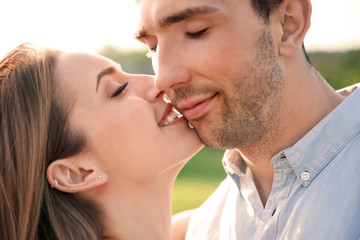Fototapeta premium Cute young couple in love posing outdoors on sunny day