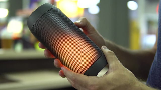 Portable speaker glows in hand.