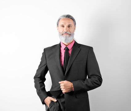 Handsome bearded mature man in suit on white background