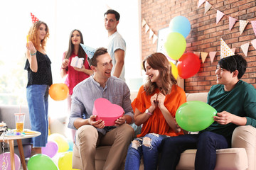 Young people having birthday party in decorated room