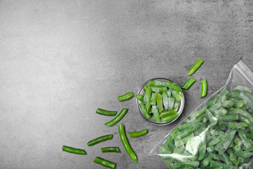 Flat lay composition with frozen green beans on grey background. Vegetable preservation