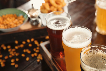 Glasses of tasty beer on wooden table, closeup