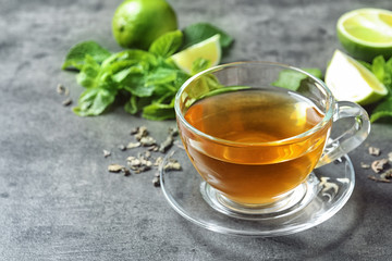 Cup with hot aromatic mint tea on table