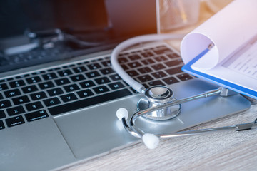 Stethoscope and prescription clipboard with record information paper folders on Laptop at medicine doctor work in hospital or clinic, Concept of Health Care and Medical. Selective focus.
