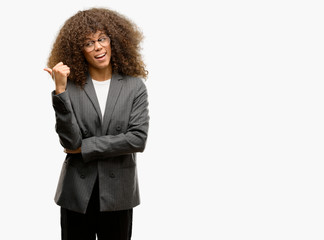 African american business woman wearing glasses smiling with happy face looking and pointing to the...