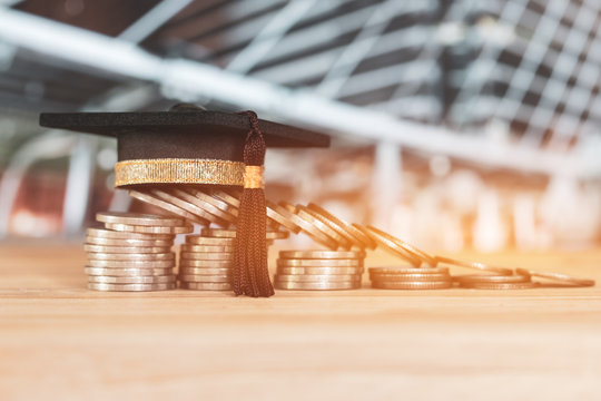 Education Graduate study scholaship concept : Congratulations graduates on top stacks of coins on wood table building background.Ideas Educational for successs study or business have to use many Money