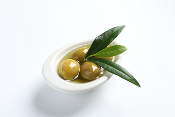 Bowl with fresh olives in oil on white background