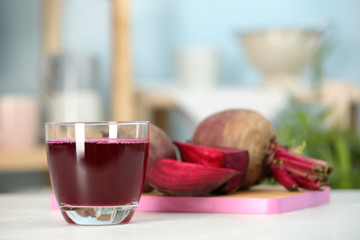 Glass with fresh healthy beet juice on table