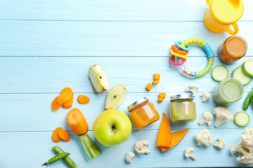 Flat lay composition with baby food and ingredients on wooden background