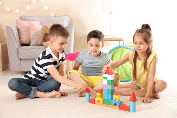 Obraz na płótnie Canvas Cute little children playing with building blocks on floor, indoors