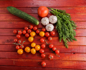 Vegetables on red wooden background.