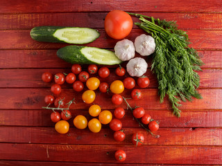 Vegetables on red wooden background.