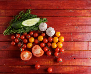Vegetables on red wooden background.
