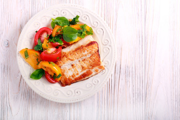 Fototapeta na wymiar Fried white fish and tomato salad
