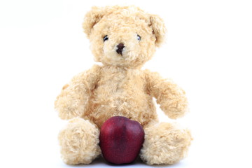 Teddy bear and red apple on a white background.