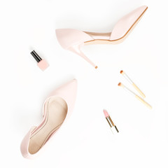 Fashion blogger workspace flat lay with pumps, cosmetics close up