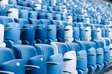 Naklejka premium Multi-colored armchairs with numbers on a football stadium. Blue and white color.