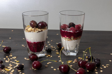 yoghurt with probiotic in a glass beaker with fruit on a dark wooden table